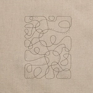 May include: A beige fabric square with a black line drawing of a maze or labyrinth pattern.