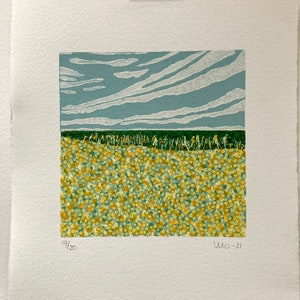 May include: A woodblock print of a landscape with a field of yellow flowers under a blue sky with white clouds. The print is numbered 19/20 and dated July 2021.