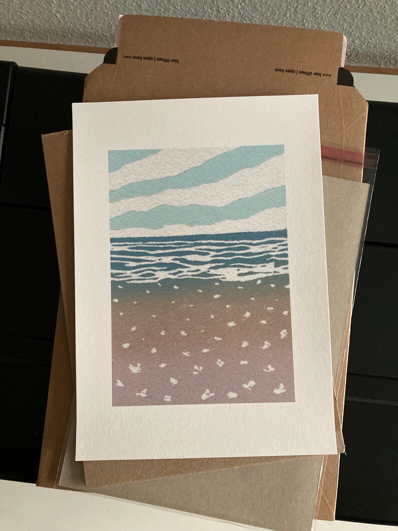 May include: A blue and white print of a seascape with a sandy beach and a blue sky with white clouds.