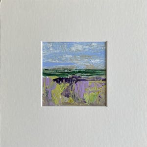 May include: A small abstract painting depicting a landscape with a blue sky, green hills, and purple flowers.