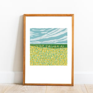 May include: A framed print of a landscape with a field of yellow flowers in the foreground, a green line of trees, and a blue sky with white clouds.