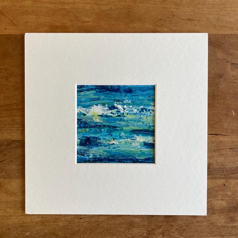 Puede incluir: Pintura abstracta de un paisaje marino azul y verde con reflejos blancos. La pintura est&aacute; enmarcada en un passe-partout blanco.