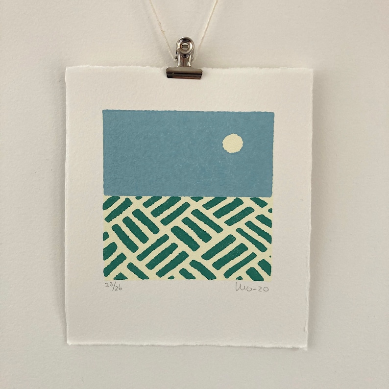 May include: A blue and green abstract print with a white circle in the upper portion of the print. The print is numbered 23/26 and signed "WG-20".
