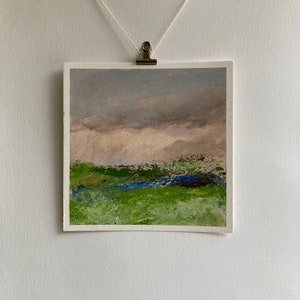 May include: Abstract landscape painting featuring a green field, blue water, and a cloudy sky. The painting is executed in a loose, gestural style with thick brushstrokes.