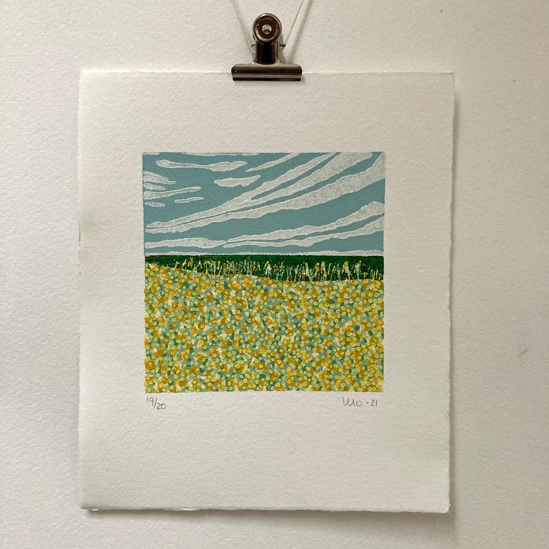 May include: A print of a landscape with a field of yellow flowers under a blue sky with white clouds. The print is numbered 19/20 and dated 2021.