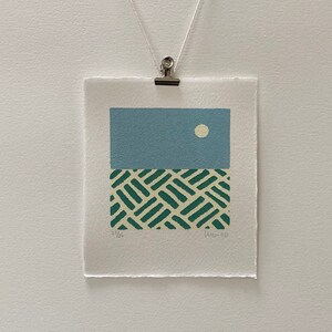 May include: A blue and green abstract print with a white circle in the top section and a green and white geometric pattern in the bottom section. The print is signed and numbered "23/26" and "Jun-20".