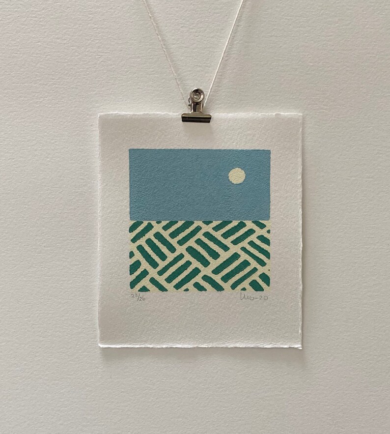 May include: A blue and green abstract print with a white circle in the top section and a green and white geometric pattern in the bottom section. The print is signed and numbered "23/26" and "Jun-20".