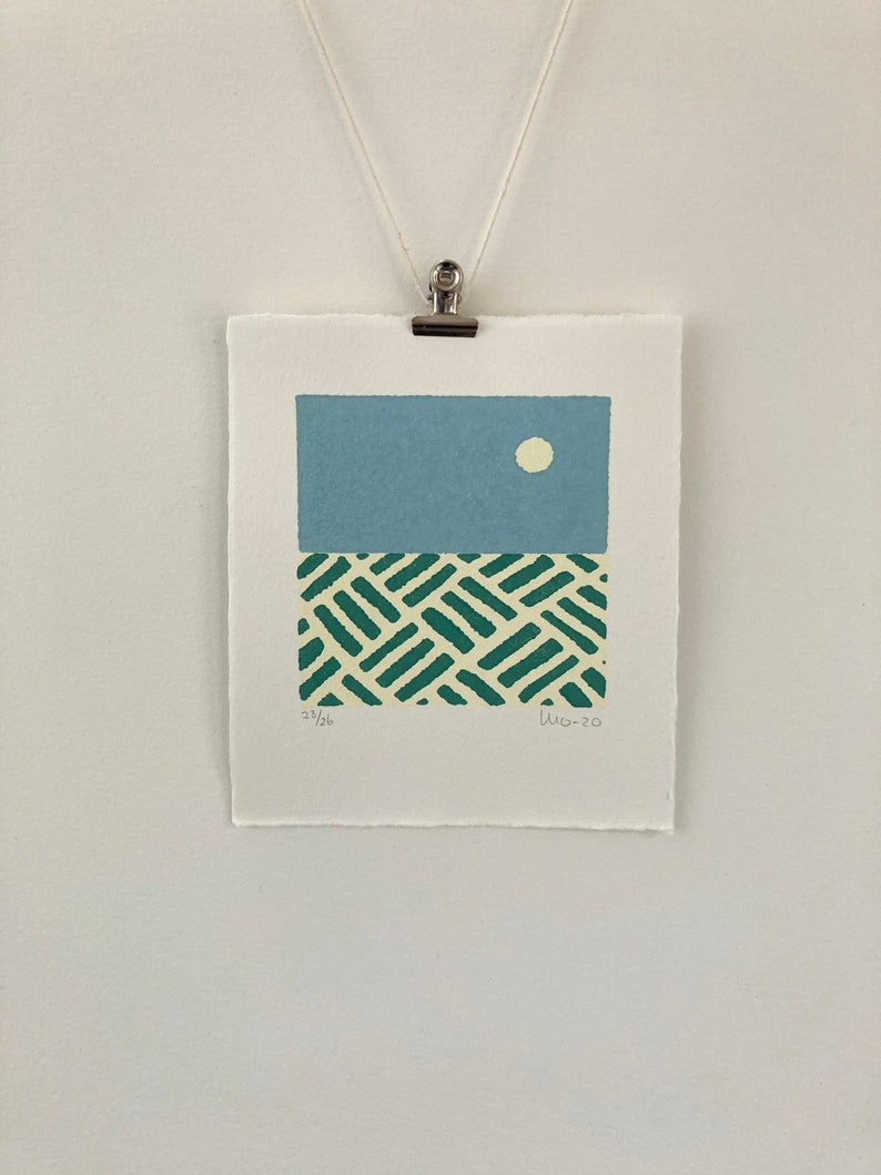 May include: A green and white geometric print with a light blue sky and a white circle above it. The print is signed "LW-20" and numbered "25/26".
