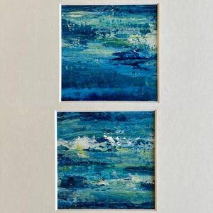 Puede incluir: Dos pinturas abstractas en tonos azules, verdes y blancos. Las pinturas est&aacute;n enmarcadas y se muestran sobre un fondo blanco.