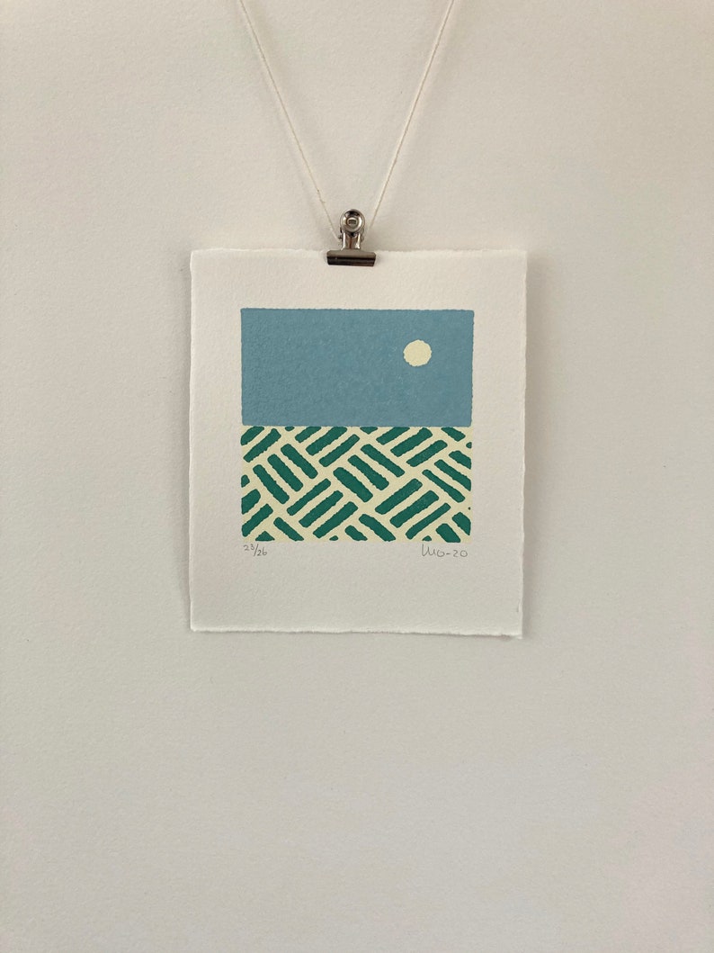 May include: A blue and green abstract print with a white circle in the upper portion of the print. The print is signed "LW 20" and numbered "23/26".