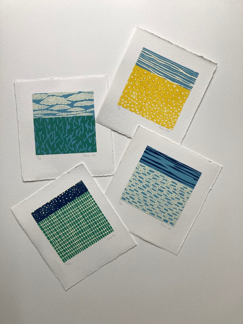 May include: Four small, square prints with different abstract patterns in blue, green, yellow, and white. The prints are numbered 1/26, 1/26, 1/26, and 1/26.