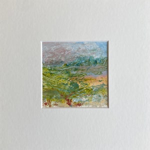 Op de afbeelding: Abstract schilderij met een landschapsthema. Het schilderij heeft een mix van groene, blauwe en bruine kleuren, met een vleugje roze op de achtergrond. Het schilderij is getextureerd en heeft een gelaagd effect.