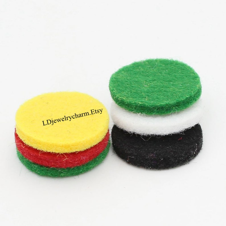 May include: Four round felt pads in green, white, black, and yellow colors. The pads are stacked on top of each other. The text "LDjewelrycharm.Etsy" is printed on the yellow pad.