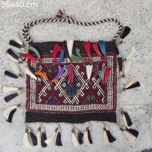 Könnte beinhalten: Eine schwarze und rote gemusterte Stofftasche mit weißen Fransen. Die Tasche hat ein geometrisches Muster und ist 35x40 cm groß.