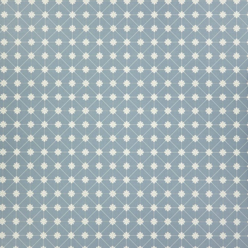 May include: A light blue fabric with a repeating pattern of white floral shapes and connecting lines. The design creates a grid-like appearance, suitable for various craft projects or home decor.