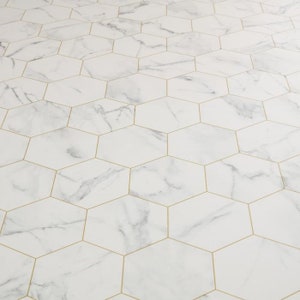 May include: White hexagonal floor tiles with gold grout lines. The tiles have a marble pattern.