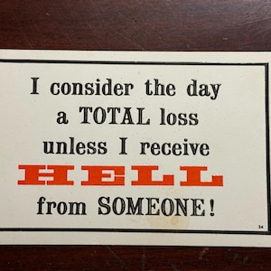 May include: A rectangular card with a black border and the text "I consider the day a TOTAL loss unless I receive HELL from SOMEONE!" in black and red. The number 34 is in the bottom right corner.