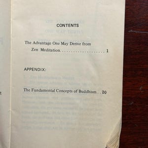 May include: Open book with the title "CONTENTS" at the top. The text includes "The Advantage One May Derive from Zen Meditation" and "The Fundamental Concepts of Buddhism". The pages are off-white.