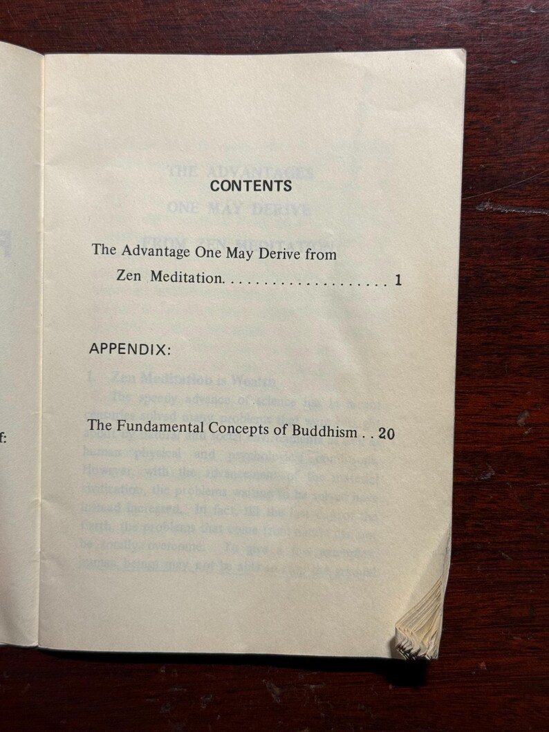 May include: Open book with the title "CONTENTS" at the top. The text includes "The Advantage One May Derive from Zen Meditation" and "The Fundamental Concepts of Buddhism". The pages are off-white.