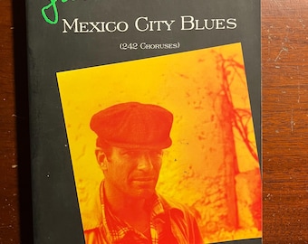 May include: A black and green book cover with the title "Mexico City Blues" by Jack Kerouac. The cover features a photo of a man wearing a cap and a quote from Allen Ginsberg.