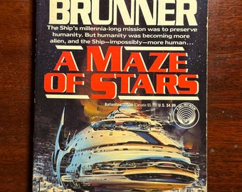 May include: Vintage paperback book titled "A Maze of Stars" by John Brunner. The cover features a futuristic spaceship illustration in shades of blue, white, and silver against a starry background. The title is in bold red letters.