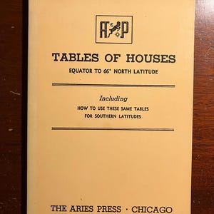 May include: A yellow book titled "Tables of Houses" with the text "Equator to 66° North Latitude" and "Including How to Use These Same Tables for Southern Latitudes". The book also has the text "The Aries Press Chicago" on the bottom.