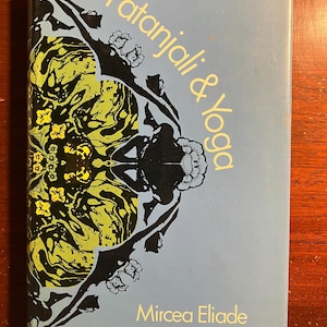 May include: A book cover with a blue background and a black and yellow illustration of a stylized figure with flowers. The title is "Patanjali & Yoga" and the author is "Mircea Eliade".