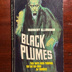 May include: Vintage paperback book cover for "Black Plumes" by Margery Allingham. The cover features a green and black illustration of a man in a long coat. The title is in large white letters, with additional text below. The book is from the McFadden MB Books series.