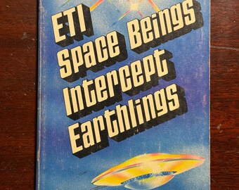 May include: A vintage paperback book titled "ETI Space Beings Intercept Earthlings" with a blue cover. The cover features a yellow and orange spaceship illustration and text in a bold, white font. The book's description is about ETI space beings.