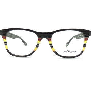 May include: Black and brown eyeglasses with a yellow and red stripe pattern on the frame. The brand name "TF Occhiali" is printed on the right lens.