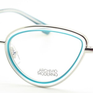 May include: Silver cat-eye glasses with a blue trim around the lenses. The brand name "Archivio Moderno" is printed on the frame.