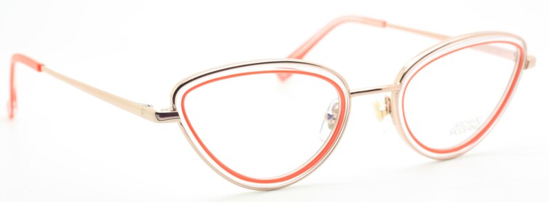 May include: Gold-tone cat-eye glasses with a bright orange accent around the lenses.