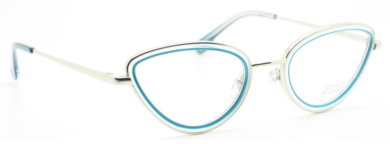 May include: Silver cat-eye glasses with a blue trim around the lenses. The brand name "ANNA KARIN" is printed on the right temple.