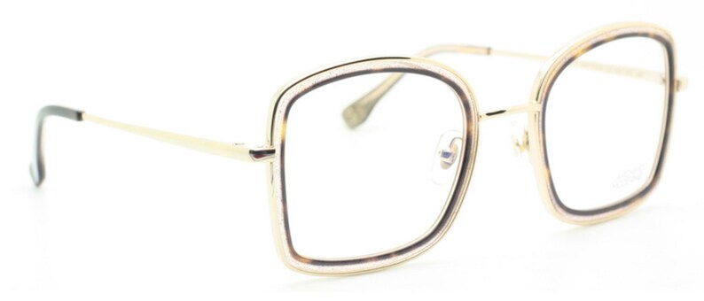 May include: Gold-tone eyeglasses with a square frame and brown tortoise shell accents. The frame has a double rim design.