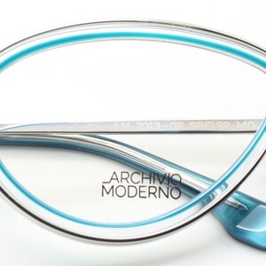 May include: Silver eyeglasses with a blue rim and a blue accent on the temple. The brand name "Archivio Moderno" is printed on the lens. The glasses have the model number "AM 7013-02 52□19 140" printed on the temple.