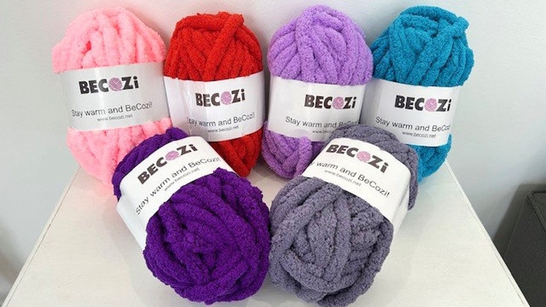 May include: Six balls of yarn in various colors, including pink, red, purple, lavender, teal, and gray. Each ball has a white label with the text "BECOZI Stay warm and BeCozi!"