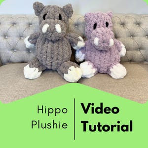 May include: Two handmade hippo plushies, one gray and one lavender, sit side-by-side. The hippos have white accents on their snouts, feet, and hands. The image includes the text "Hippo Plushie Video Tutorial" on a green background.