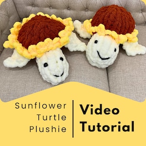 May include: Two crocheted sunflower turtle plushies. The turtles are brown with yellow sunflower accents and white faces. The image includes the text "Sunflower Turtle Plushie Video Tutorial".