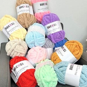 May include: Assortment of colorful yarn balls in various shades of pink, blue, green, yellow, orange, and red. Each ball has a white label with the text "BECOZI Stay warm and BeCozy".