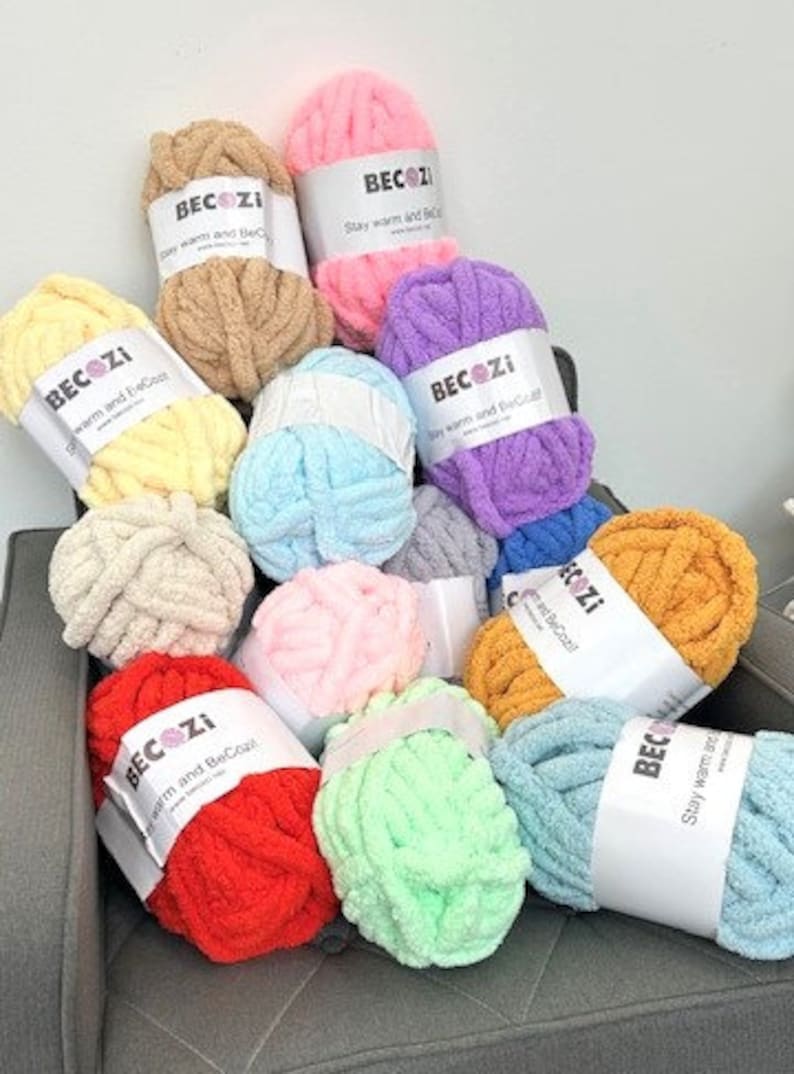 May include: Assortment of colorful yarn balls in various shades of pink, blue, green, yellow, orange, and red. Each ball has a white label with the text "BECOZI Stay warm and BeCozy".