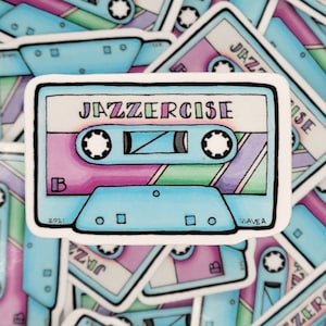 May include: A blue and white cassette tape sticker with the text "Jazzercise" in rainbow colors. The sticker has a pink, green, and purple design on the tape.