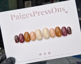 May include: A set of ten press-on nails in various shades of brown, beige, and burgundy. The nails are arranged in a gradient from darkest to lightest. The text "PaigesPressOns" is printed on the card.