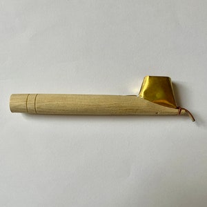 May include: A wooden calligraphy pen with a brass nib and a red string attached to the nib.