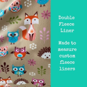 May include: Beige fleece fabric with a repeating pattern of owls, foxes, hedgehogs, and flowers. The text "Double Fleece Liner" and "Made to measure custom fleece liners" is printed on the right side of the image.