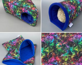 May include: A set of three colorful galaxy print hedgehog hideaways. The hideaways are made of soft fabric with a blue fleece lining. The hideaways include a tunnel, a wedge, and a pouch.