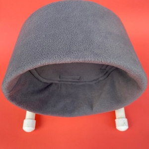 May include: Gray fleece hat with a white brim and two white straps attached to the sides.