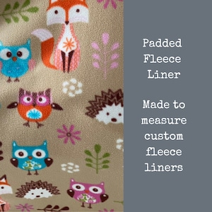 May include: A close-up of a beige fabric with a repeating pattern of owls, foxes, and hedgehogs. The fabric has a soft, fuzzy texture. The text "Padded Fleece Liner Made to measure custom fleece liners" is visible on the right side of the image.
