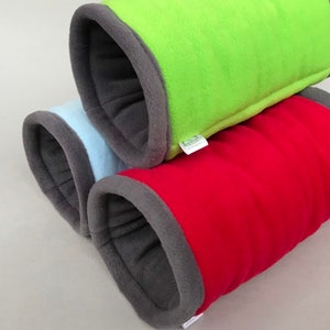 May include: Three fabric pet tunnels in different colors: green, red, and light blue. Each tunnel has a gray fleece lining and is made of soft, plush fabric.
