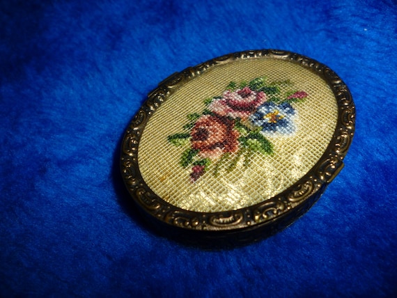 Compact with embroidered top