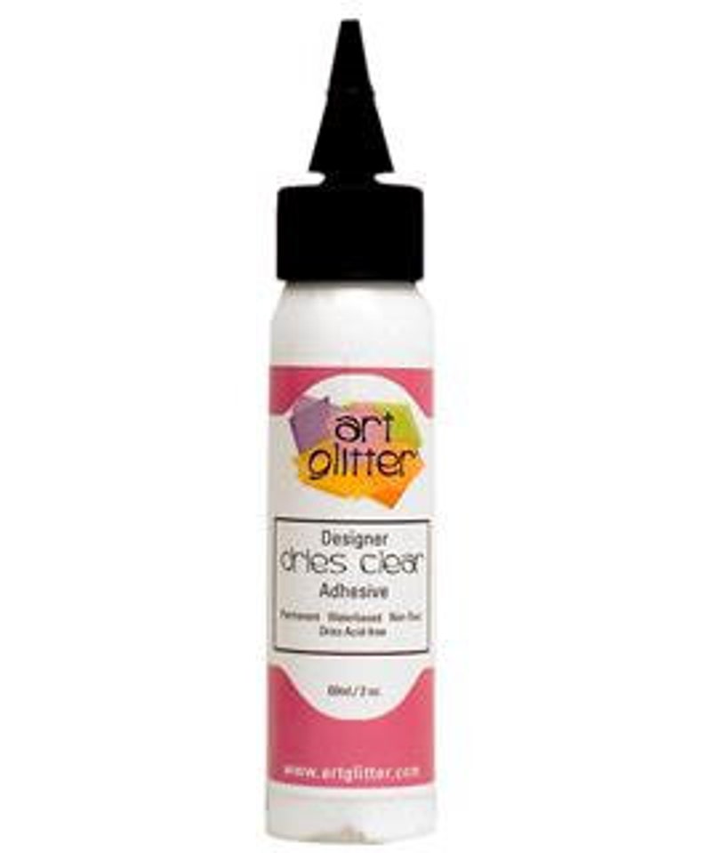 May include: A 4 oz bottle of clear, white, dries clear adhesive. The bottle has a black cap with a pointed tip. The label is pink and white with the text "Art Glitter Designer dries clear Adhesive" and "Permanent, Waterbased, Non-toxic, Dries Acid Free".